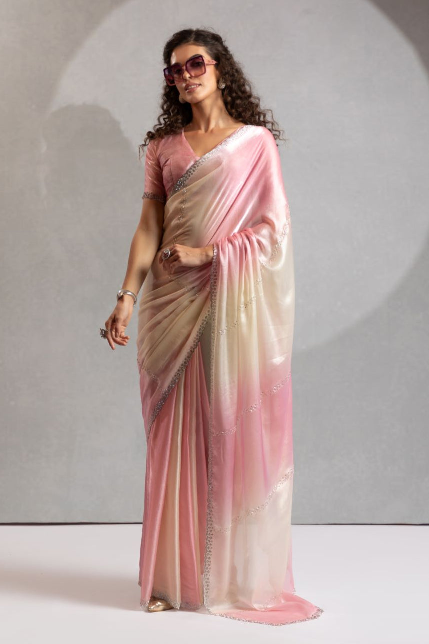 Woman wearing a pink and beige saree with sunglasses against a neutral background