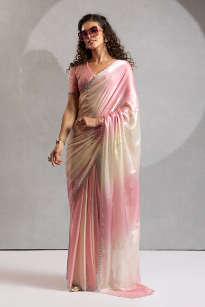 Woman wearing a pink and beige saree with sunglasses against a neutral background